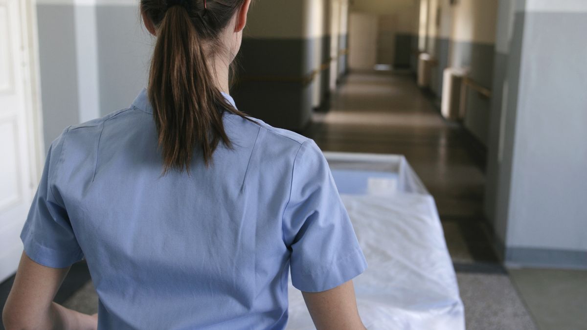 A nurse pushing a hospital gurney down a hallway
Team Static
