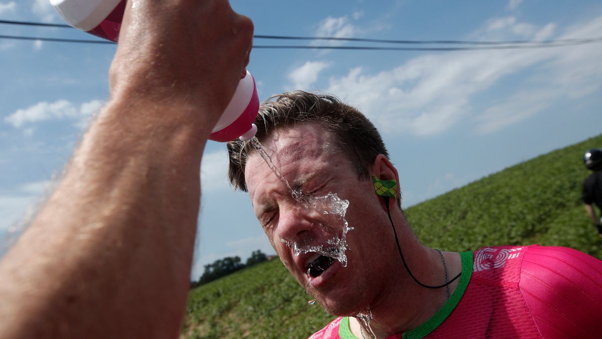 Australijczyk Simon Clarke z grupy Drapac Cannondale przemywa oczy po wjechaniu w chmurę gazu pieprzowego