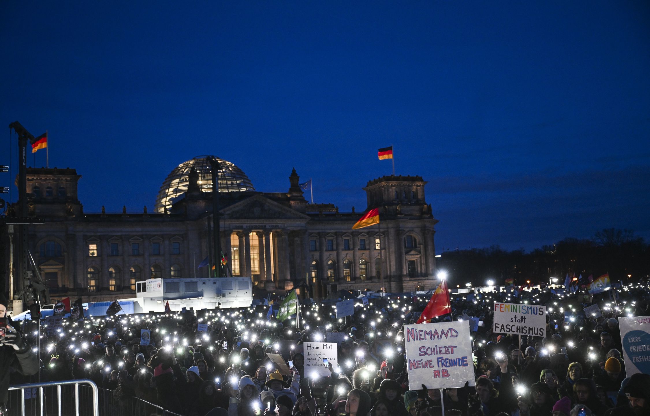 BERLIN, GERMANY - JANUARY 21: People protest against the far-right Alternative for Germany (AfD) political party and racism as they carry banners and hold flashlights near the Bundestag in Berlin, Germany on January 21, 2024. (Photo by Halil Sagirkaya/Anadolu via Getty Images)