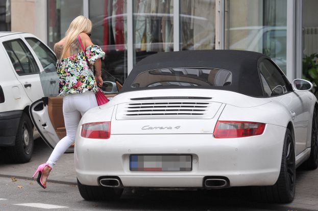 Doda w białych spodniach wsiada do białego Porsche