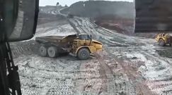 Budowlańcy się bawią dużą ciężarówką na placu budowy jak resorakiem w piaskownicy