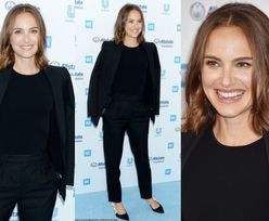 Pogodna Natalie Portman w czarnym garniturze uśmiecha się na ściance