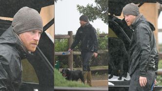 Posępny książę Harry spaceruje z psem w ulewnym deszczu (ZDJĘCIA)