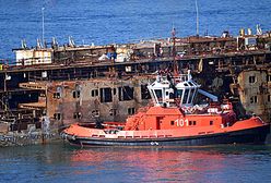 Wrak statku Costa Concordia holowany do portu w Genui