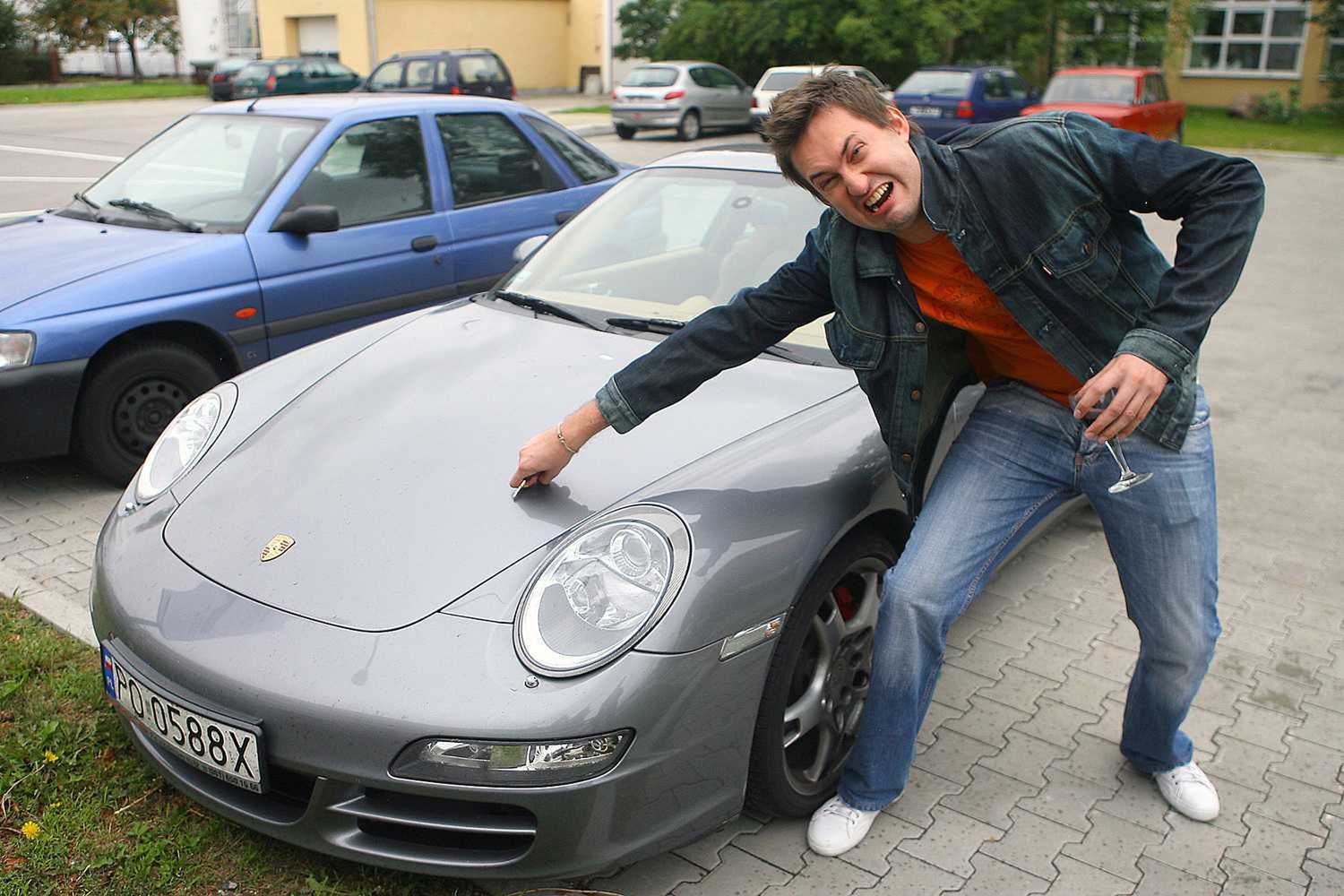 Marcin Prokop przy luksusowym samochodzie