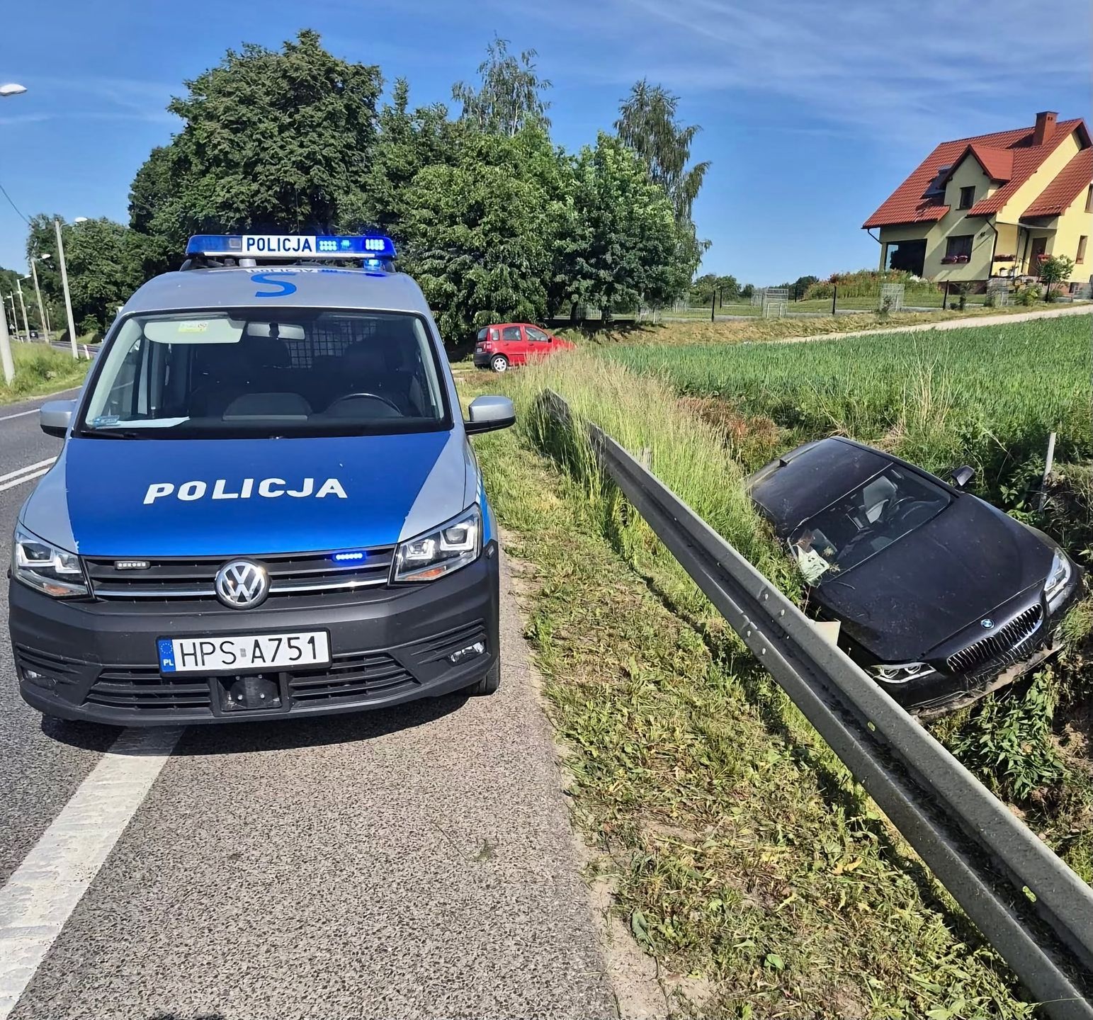 Na miejscu zdarzenia - radiowóz i pojazd, który zjechał z drogi