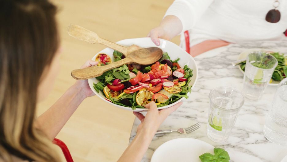 Mint Images RF batch 63 Aug 2016
View from above of a table laid with cutlery and plates of prepared food. A woman holdng a salad plate.
Mint Images