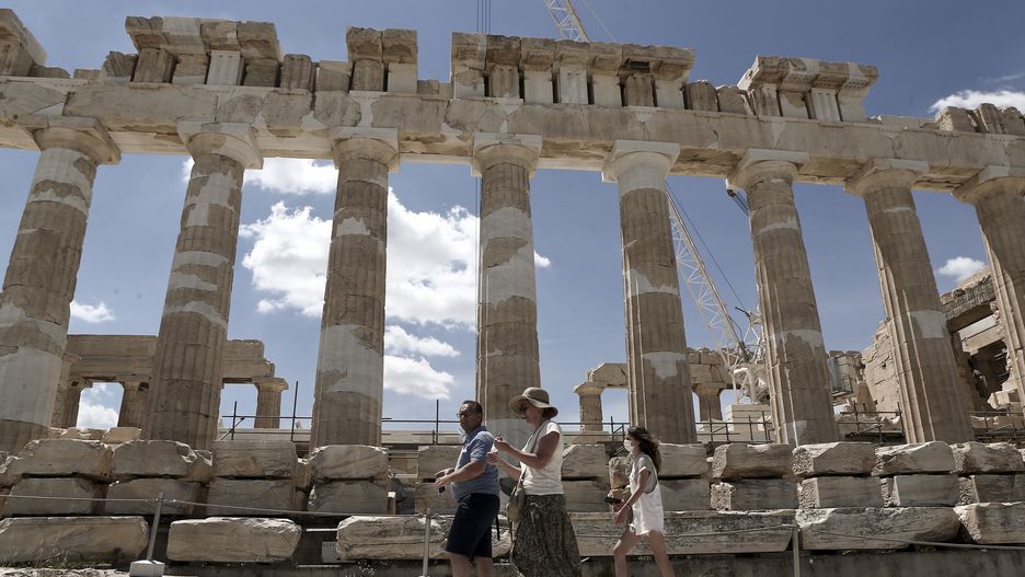 Tourist walk in front the ancient temple of Parthenon at the Acropolis hill, on June 2, 2021 (Photo by Panayotis Tzamaros/NurPhoto via Getty Images)