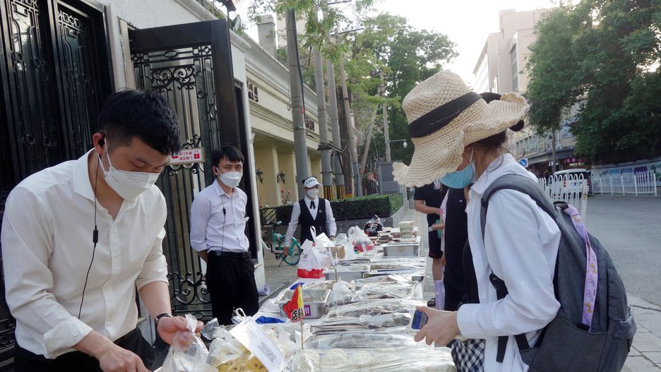 BEIJING, CHINA - MAY 21 2022: The waiter packs food for a pedestrian stopping by a food stall set up outside a restaurant in Beijing, China Saturday, May 21, 2022, after the city banned dine-in services amid the COVID-19 outbreak. (Photo credit should read FAN SHUMEI/ Feature China/Future Publishing via Getty Images)