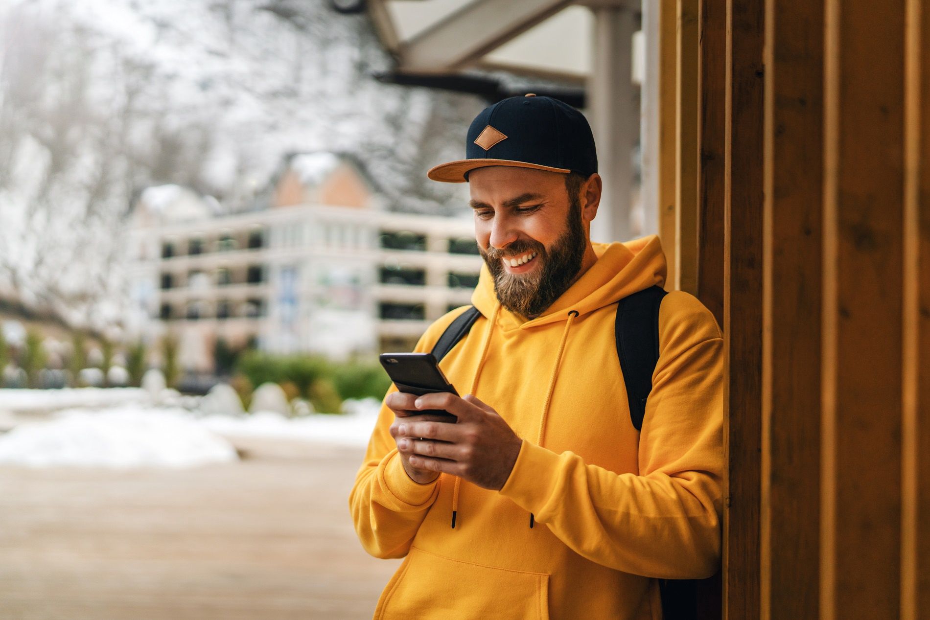 Front view. Bearded male tourist in yellow hoodie and cap with black backpack stands outdoors and using smartphone. Lifestyle.Front view. Bearded male tourist in yellow hoodie and cap with black backpack stands outdoors and using smartphone. Hipster man checks e-mail on smartphone, browses social networks. Lifestyle.photo, nature, tourist, landscape, mountain, young, lifestyle, phone, taking, man, person, photography, tourism, travel, mobile, outdoor, photograph, smartphone, male, view, cell, photographer, background, digital, guy, traveler, holding, casual, hipster, people, trip, screen, back, men, one, photographing, hands, journey, outdoors, rear, shot, Sochi, yellow, hoodie, bearded, baseball cap, touching, snow, backpack, using