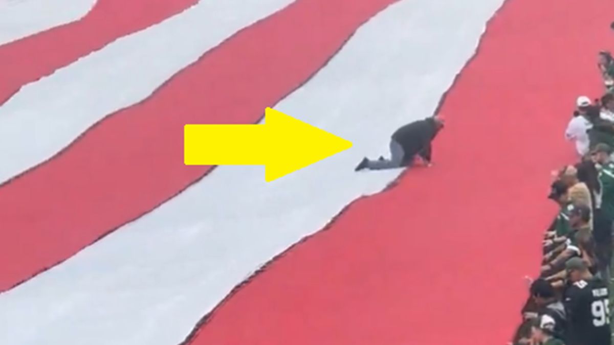 Twitter / Na zdjęciu: człowiek na fladze USA podczas meczu NFL