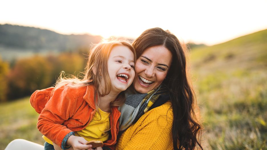 A portrait of young mother with a small daughter in autumn nature at sunset.A portrait of young mother with a small daughter sitting on a ground in autumn nature at sunset.family, beautiful, woman, females, mother, mommy, parent, child, kid, offspring, daughter, small, girl, two, people, together, caucasian, love, happy, outdoors, outside, nature, park, autumn, fall, lifestyle, leisure, colorful, leaves, orange, red, trees, sunset, sun, evening, sitting, ground, grass, jacket, scarf, young, laughing, long, dark, hair, having, fun, time