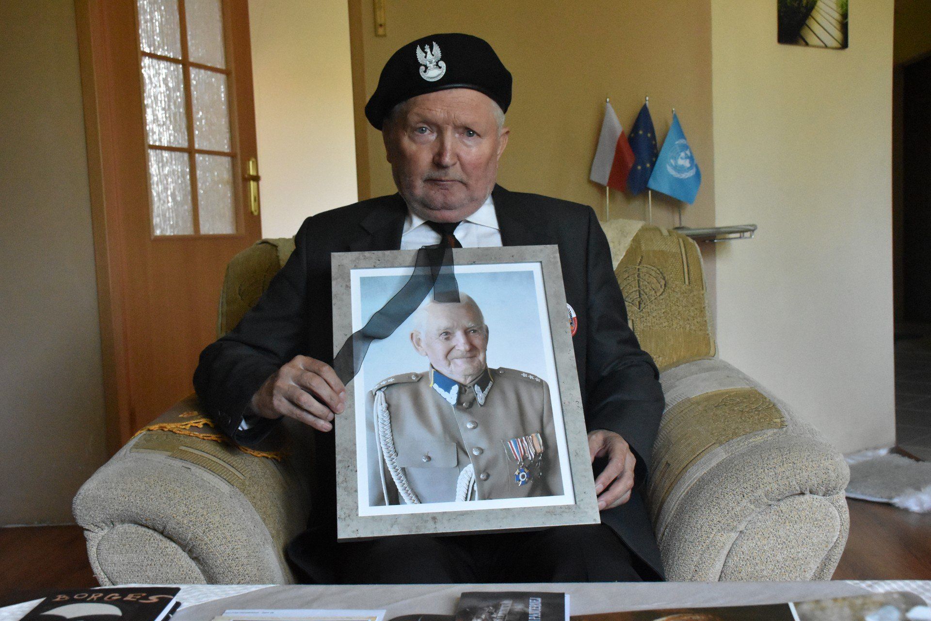 Marian Kwidziński z Białogardu trzymający fotografie nieżyjącego ojca