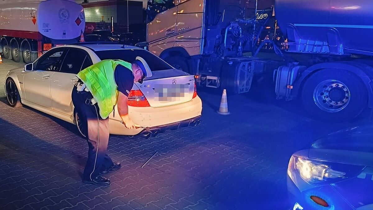 Policjant sprawdza głośność wydechu Mercedesa w ramach akcji "stop-drift"