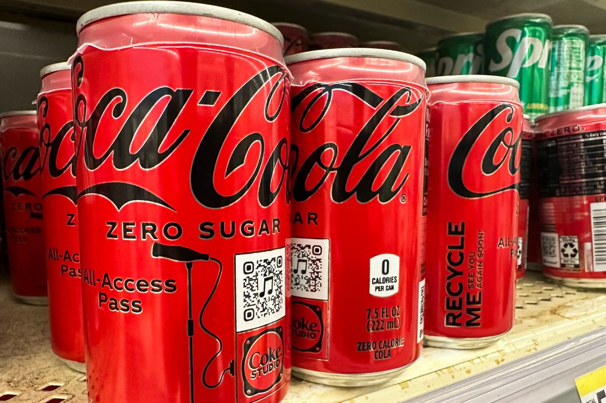 Cans of cola on the shelf in the store