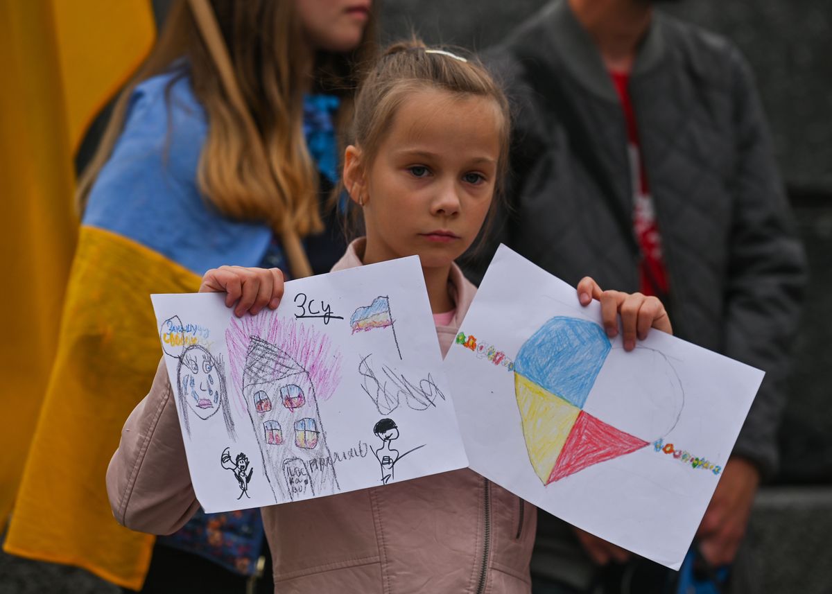 Maria (age 8) from Zhytomyr, Ukraine, holding a hand-made drawings.
Ukrainians and Belarusians living in Krakow, supported by local Poles, seen during their 139th day of the 'NATO Close The Sky' protest at Adam Mickiewicz statue in Krakow's Main Market Square. 
On Tuesday, July 12, 2022, in Free Ukraine Square, Krakow, Poland. (Photo by Artur Widak/NurPhoto via Getty Images)