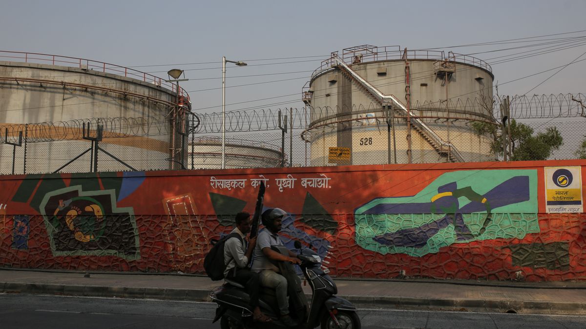 A motorist rides past an oil refinery operated by Bharat Petroleum Corp. Ltd., in Mumbai, India,  on Friday, April 4, 2025. Indian refiners have rushed back to the market to seek crude supply after President Donald Trump's threat of more penalties against Russia raised concerns over potential disruptions to oil flows. Photographer: Dhiraj Singh/Bloomberg via Getty Images