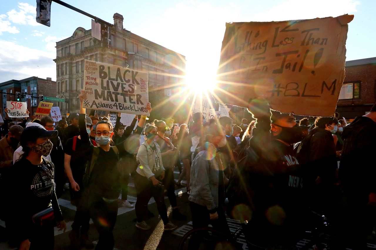 Boston. Protestujący spokojnie idą ulicami z transparentami.