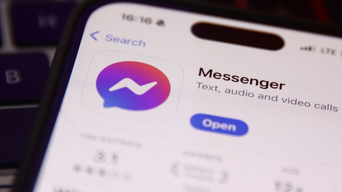 Messenger on App Store displayed on a phone screen and French flag displayed on a screen in the background are seen this illustration photo taken in Krakow, Poland on December 3, 2023. (Photo by Jakub Porzycki/NurPhoto via Getty Images)