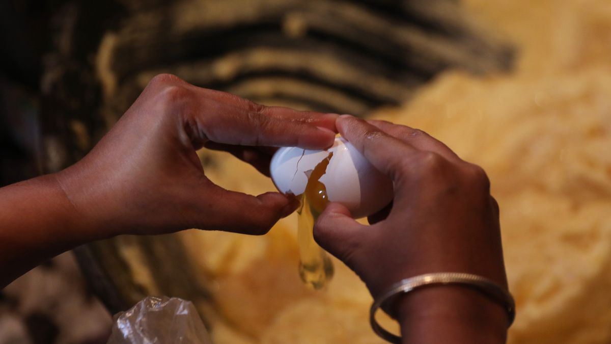 A woman breaks an egg into cake batter before baking her customized Christmas fruit cake inside a traditional bakery ahead of the Christmas celebration in Kolkata, India, on December 23, 2024. (Photo by Rupak De Chowdhuri/NurPhoto via Getty Images)