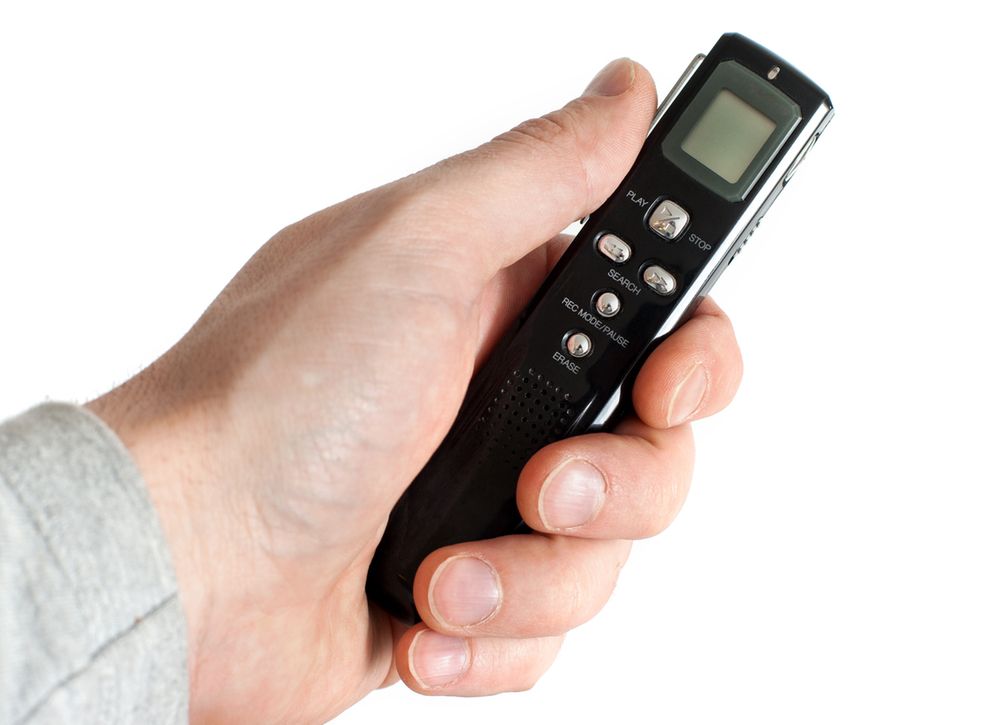 Zdjęcie Male hand holding Audio Recorder using for documenting sound pochodzi z serwisu Shutterstock