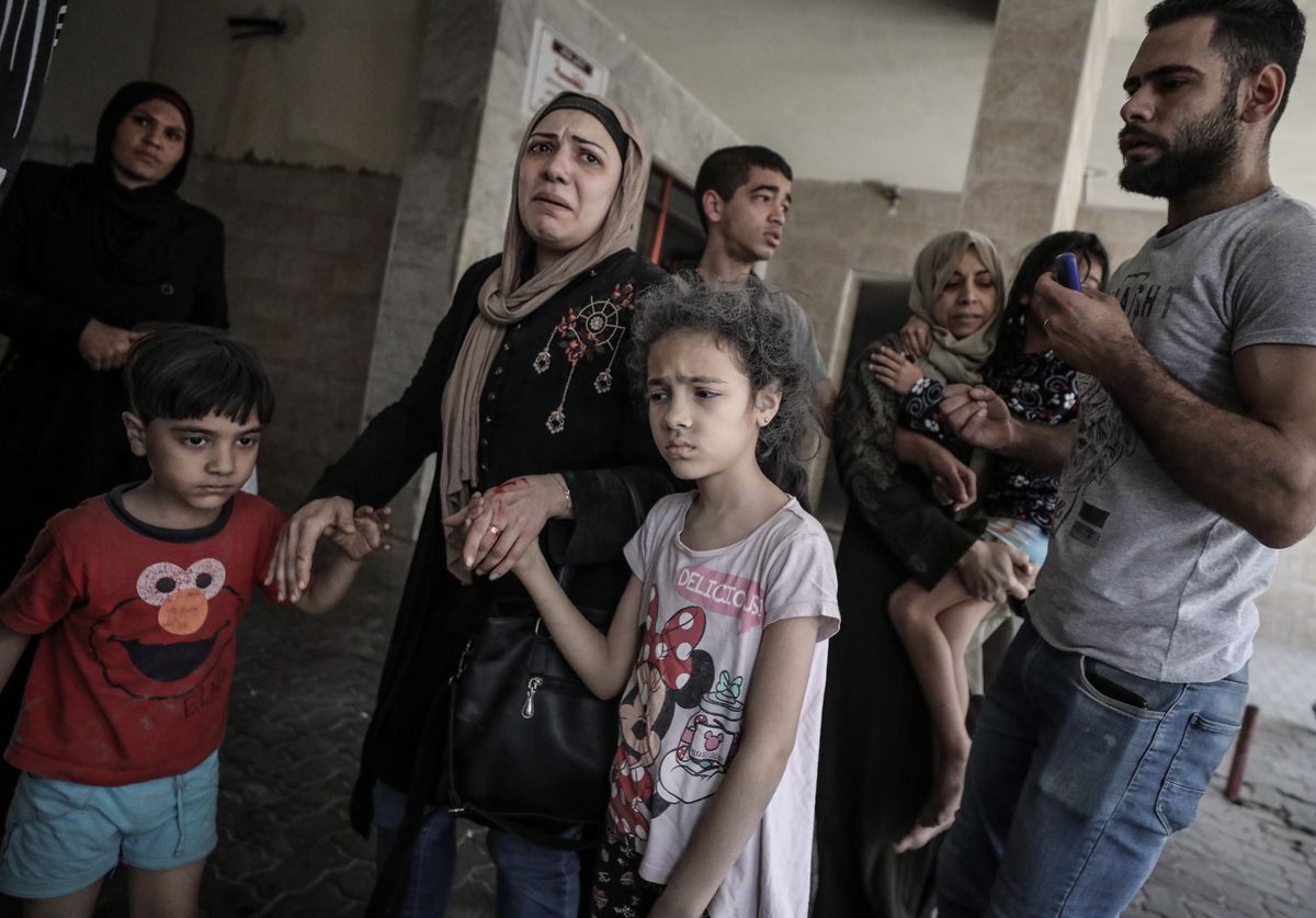 Palestyńczycy ewakuowani z jednego ze zbombardowanych budynków w Strefie Gazy