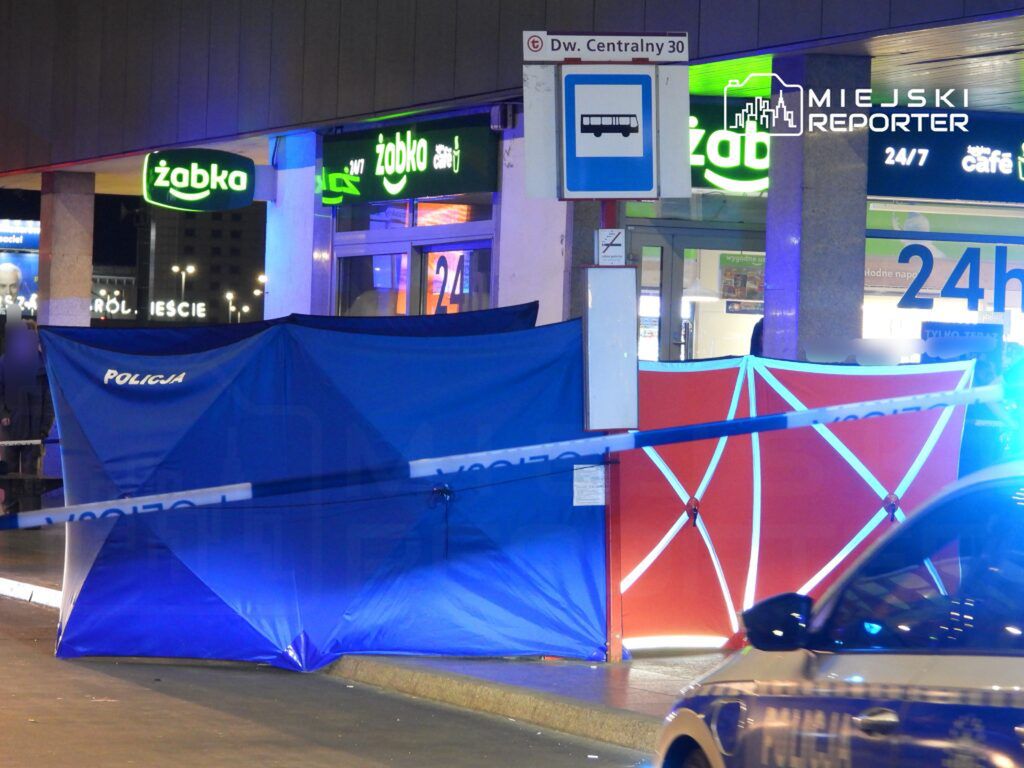 Policja zabezpiecza miejsce zdarzenia przed sklepem Żabka, używając niebieskich i czerwonych namiotów.