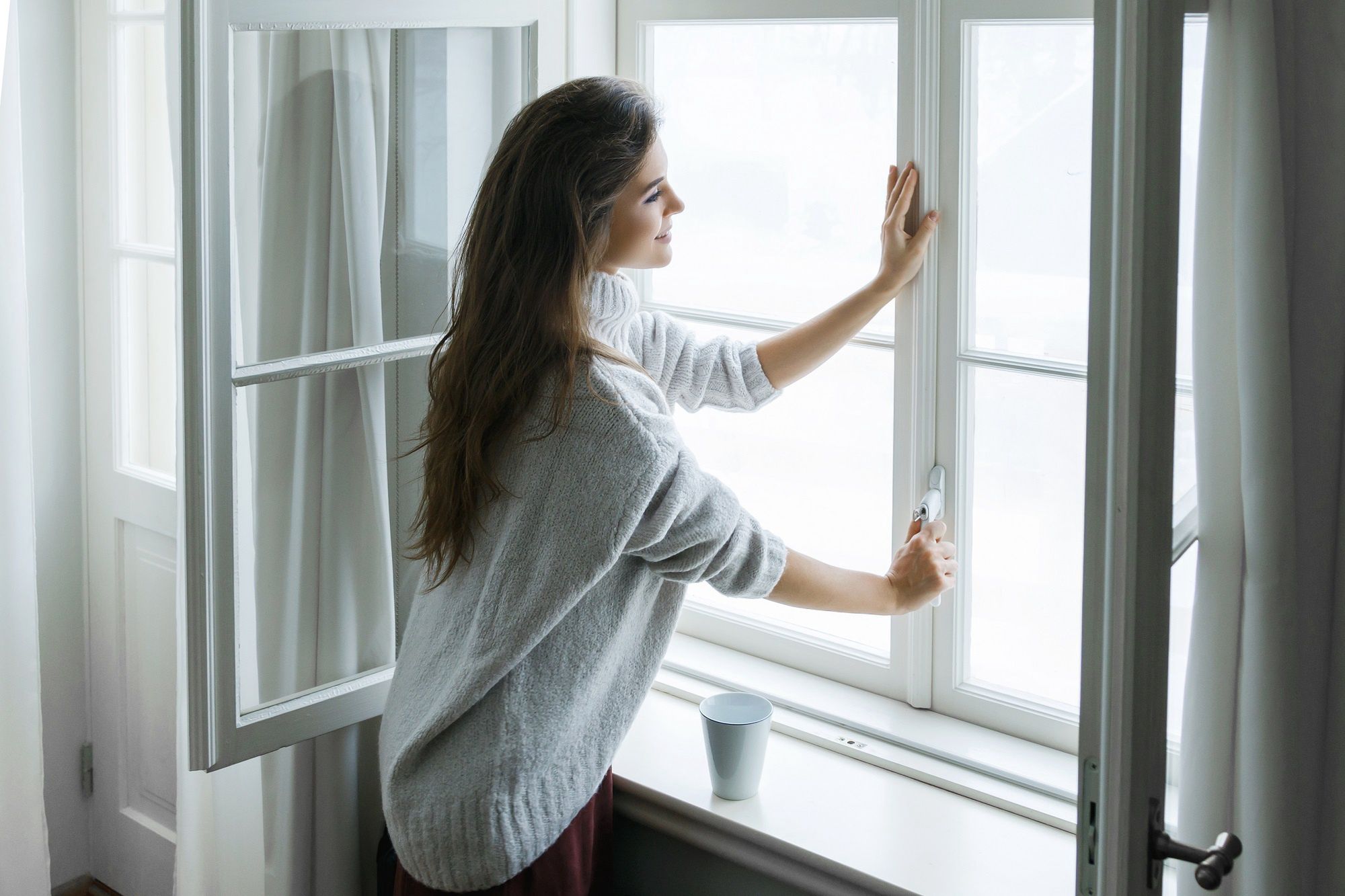 Woman is opening window to look at beautiful snowy landscape outsideblackdaygirl, woman, model, house, home, homey, cozy, coziness, comfortable, warm, large, window, day, open, closing, cold, winter, temperature, indoors, happy, enjoyment, attractive, beautiful, cute, smiling, cashmere, pullover, white, windowsill, heat, long, brown, hair, natural, relaxation, holiday, vacation, pleasure, leisure, rest, atmosphere, sweater, woolen, snow, frost, cup, hot, tea, coffee, drink