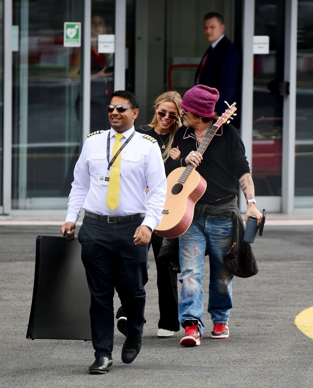 Johnny Depp rushes through the airport alongside a mysterious blonde.