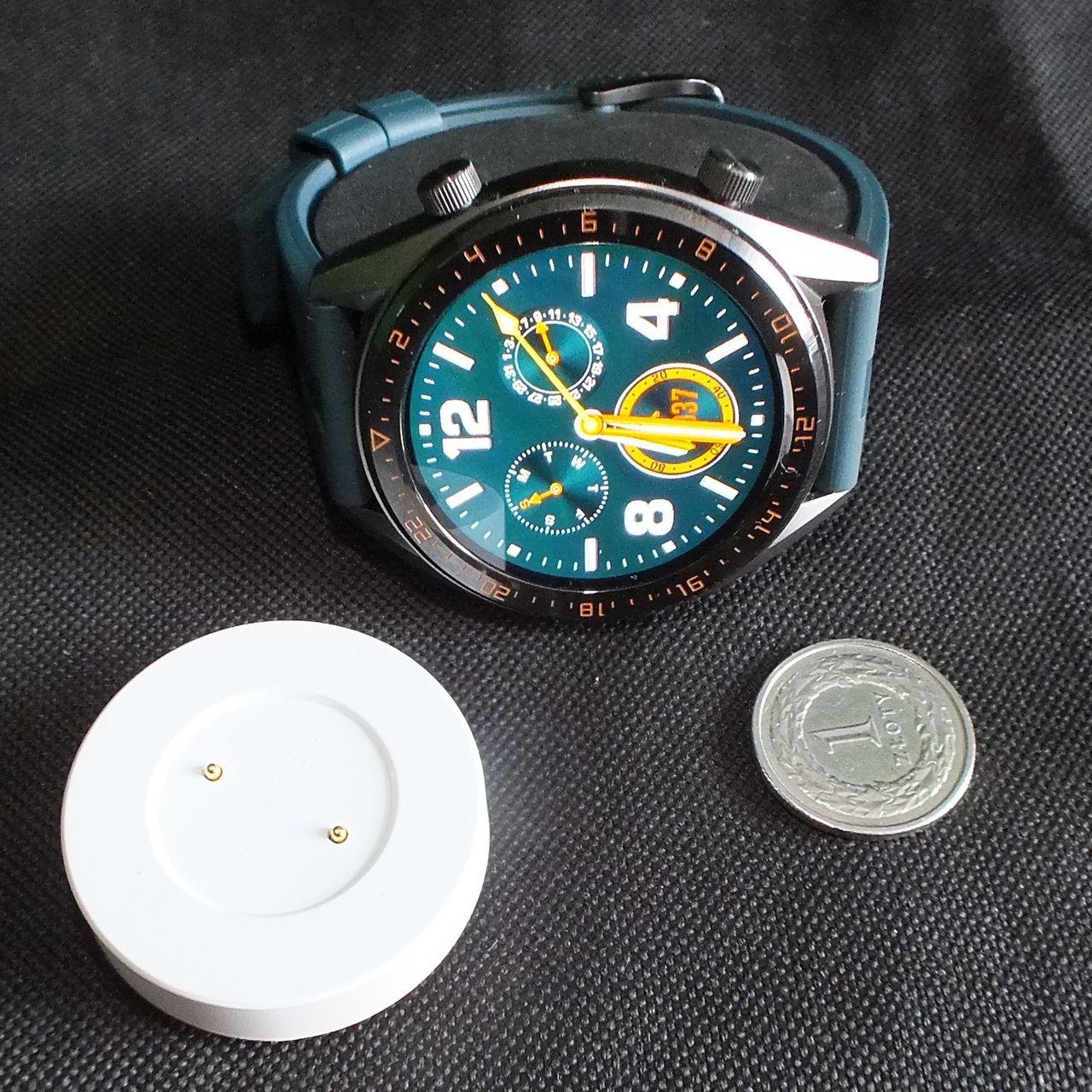 Wielkość zegarka i podstawki ładującej w porównaniu do jednozłotówki