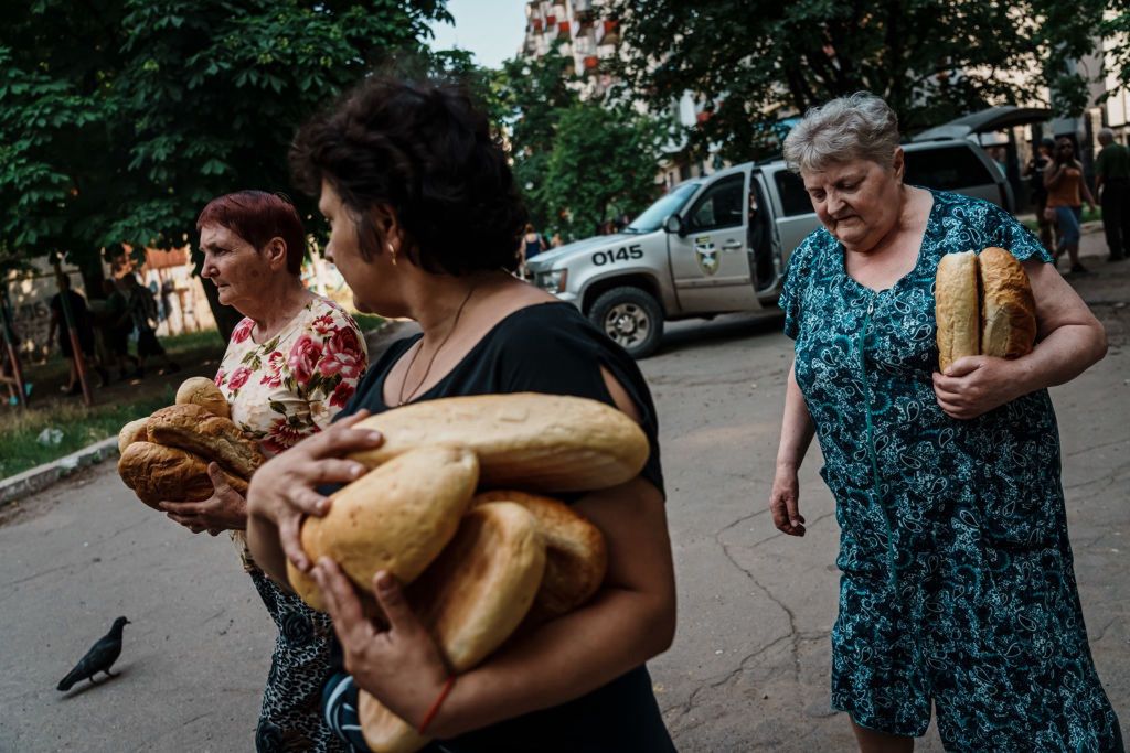 UKRAINE RUSSIAN WARLYSYCHANSK, UKRAINE -- JUNE 11, 2022: Residents in a carry their food given out by police officers, in Lysychansk, Ukraine, Saturday June 11, 2022. (Marcus Yam / Los Angeles Times via Getty Images)Marcus Yamrussian, united states, separatist region, escalation, donbas, buildup, ukrainian, america, tension, troop, joe biden, vladimir v. putin, standoff, invasion, volodymyr zelensky, instability, border, ukr, civilian casualty