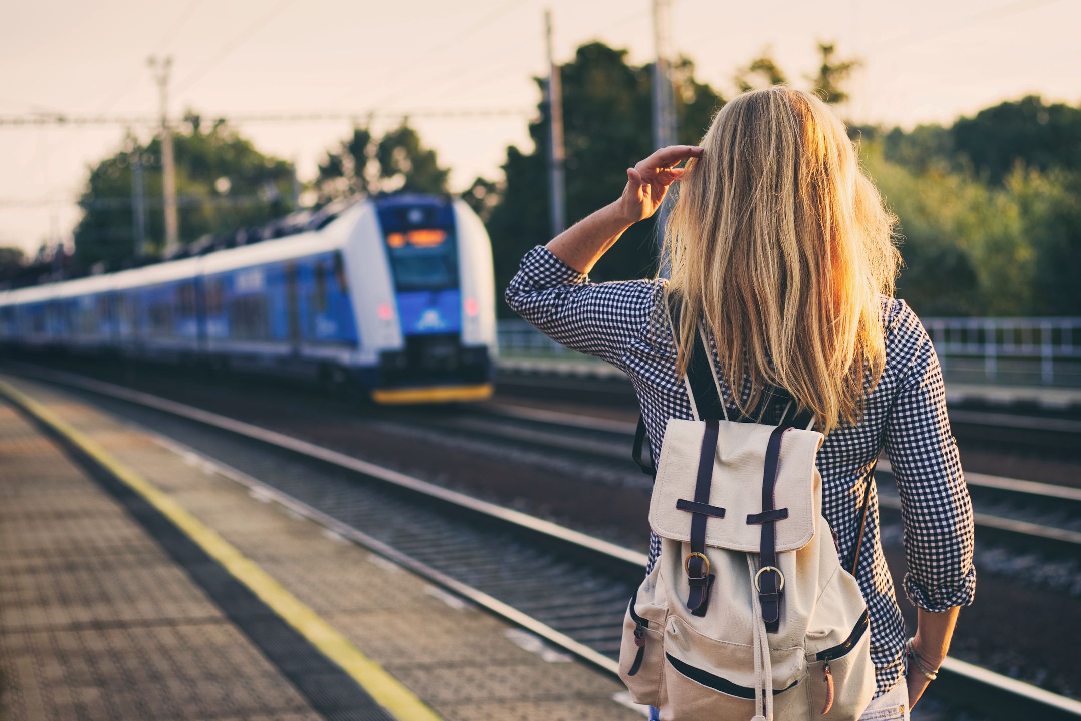 railway, train, woman, travel, tourist, tourism, transport, station, arrival, railroad, rail, track, backpack, transportation, platform, looking, travelling, europe, blond hair, traveler, vacation, train station, people, stand, hipster, millennial, backpacker, young, shirt, casual, summer, departure, one person, concept, mode of transport
