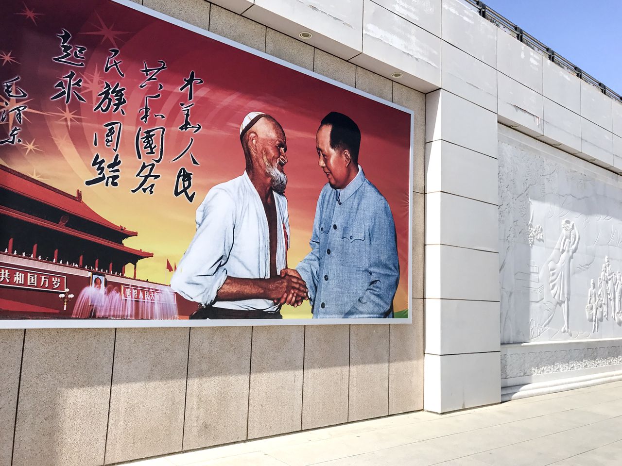 Turpan north railway station. A Chinese propaganda poster of Mao Zedong shaking hands with Uyghurs