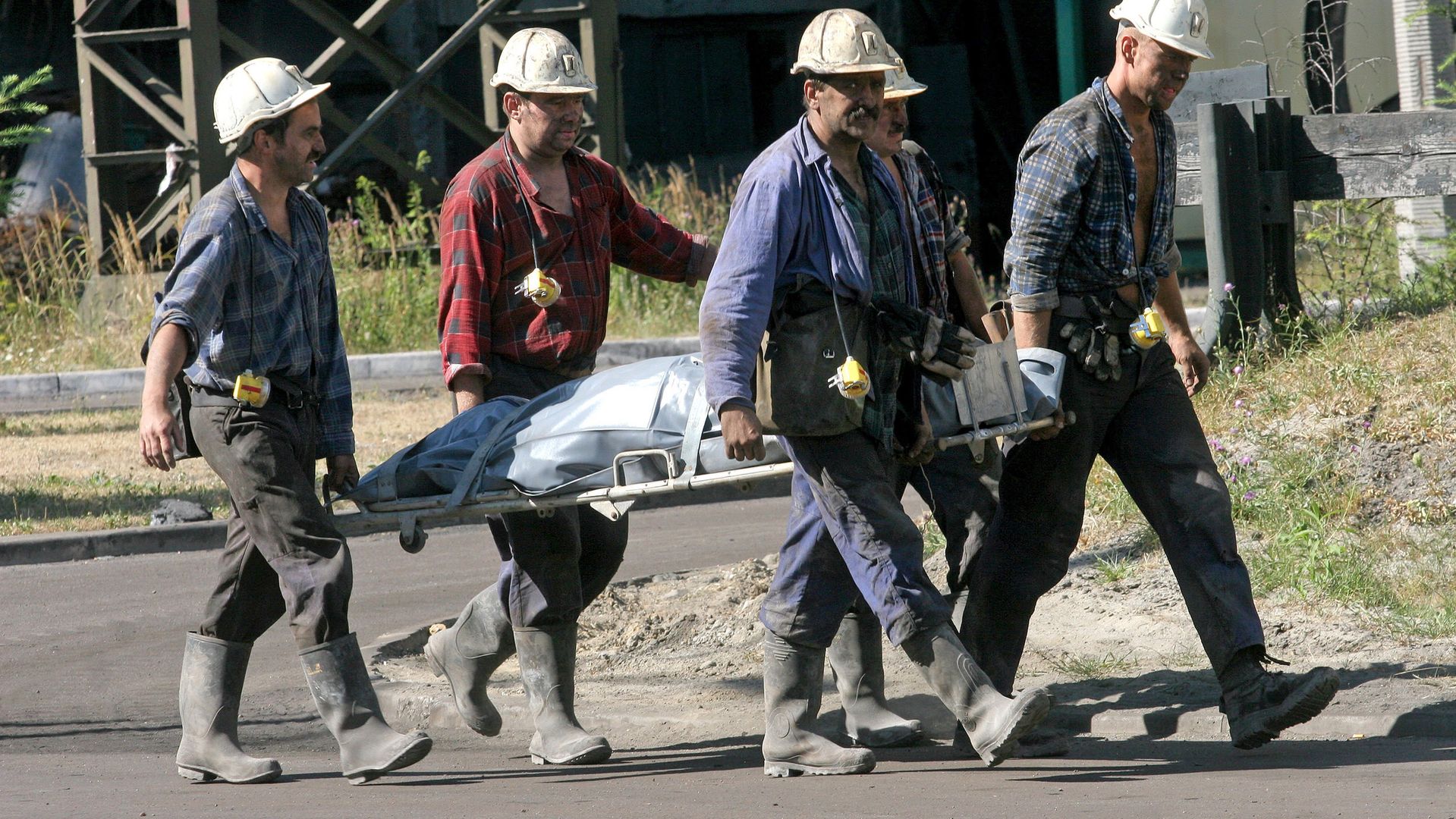 Ratownicy niosą ciało górnika po wypadku w kopalni "Pokój" w Rudzie Śląskiej, 28.07.2006 r.