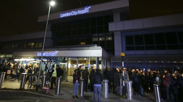 Pasażerowie przed budynkiem portu lotniczego