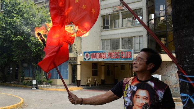 Filipiński aktywista, który pali flagę Chin w proteście przeciwko roszczeniom tego państwa wobec obszarów Morza Południowochińskiego