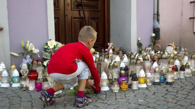 Kwiaty i znicze przed księgarnią w Kamiennej Górze, gdzie 27-letni mężczyzna zaatakował 10-letnią dziewczynkę siekierą