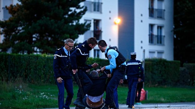 Policjanci pomagają dziennikarzowi zaatakowanemu przez Romów po strzelaninie w Roye