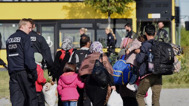 Niemiecka policja asystuje grupie imigrantów