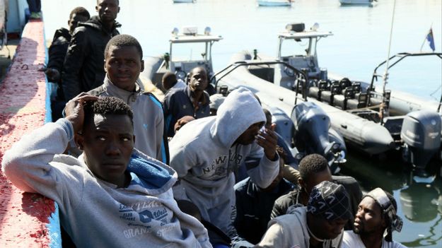 Migranci czekają w dokach Tripolisu po tym, jak ich łódź zatonęła niedaleko wybrzeża