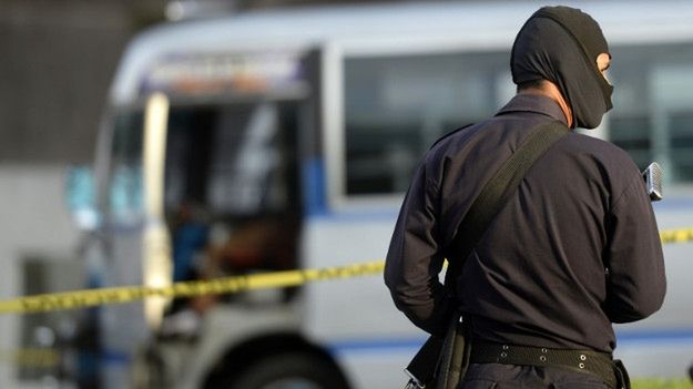 Policjant na miejscu zabójstwa kierowcy autobusu przez rzekomych członków gangu; San Salwador, lipiec 2015 r.
