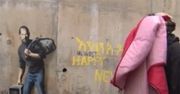 Uchodźcy w Calais zarabiają na muralu Banksy'ego