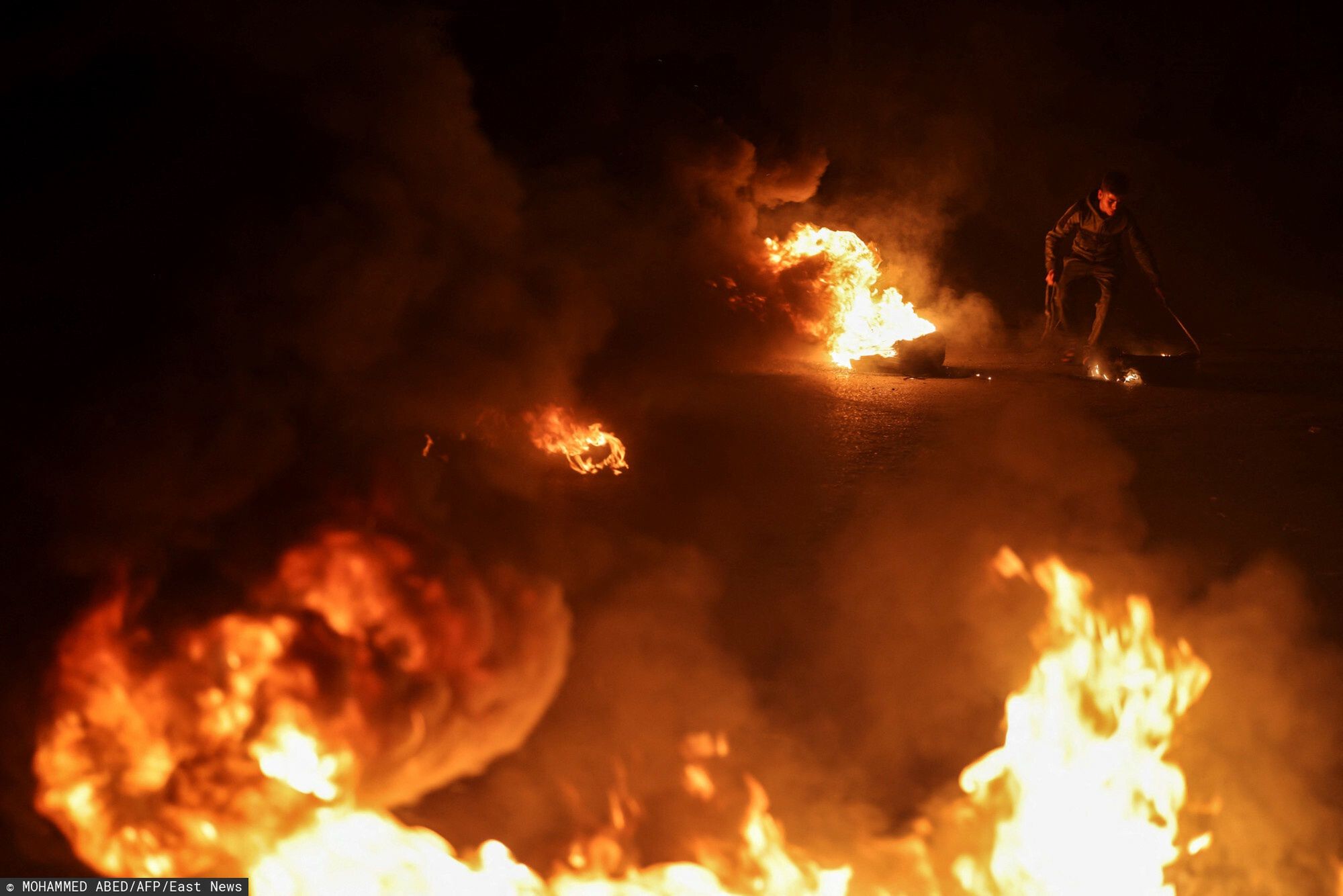 Temporary
Palestinian youth react as they burn tires during a protest on the streets of Gaza City on April 5, 2023. - After the announcement of the clashes at Al-Aqsa mosque in Jerusalem early on April 5, 2023, several rockets were fired from the northern Gaza Strip towards Israeli territory, according to AFP journalists and witnesses.
AFP journalists said they saw three rockets fired from afar and witnesses said they saw others, while the Israeli army reported rocket warning sirens had been triggered in several Israeli urban centres around the Gaza Strip. (Photo by Mohammed ABED / AFP)
MOHAMMED ABED