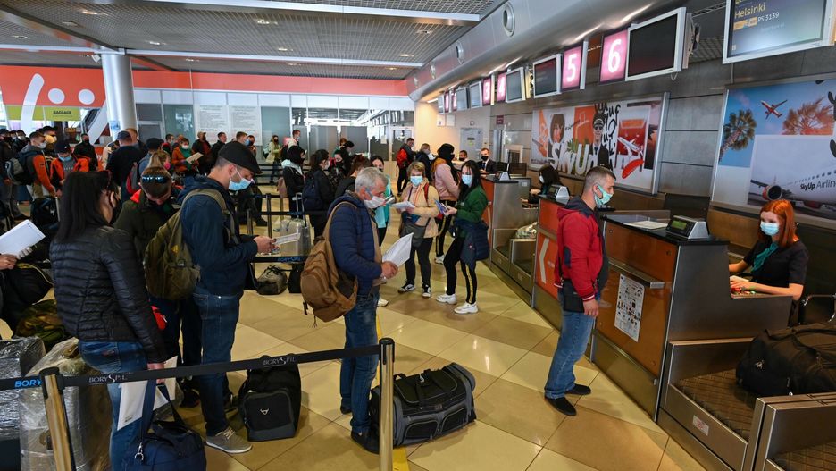 TemporaryUkrainian seasonal workers wearing face mask wait in line to check in to a flight to Finland at Boryspil airport in Kiev on May 13, 2020. - In an almost empty terminal at Boryspil airport in Kiev, Yuriy was waiting in a busy line of 200 seasonal workers to check in to a lone flight to Finland. The flight was an exception after Ukraine closed its borders and grounded air travel in March to contain the coronavirus, stranding Ukrainian labourers who would usually be harvesting crops on farms throughout Europe. Faced with the prospect of fruits and vegetables rotting in fields, farmers in countries including the United Kingdom and Finland moved to solve the problem by chartering flights for workers. (Photo by GENYA SAVILOV / AFP)GENYA SAVILOV