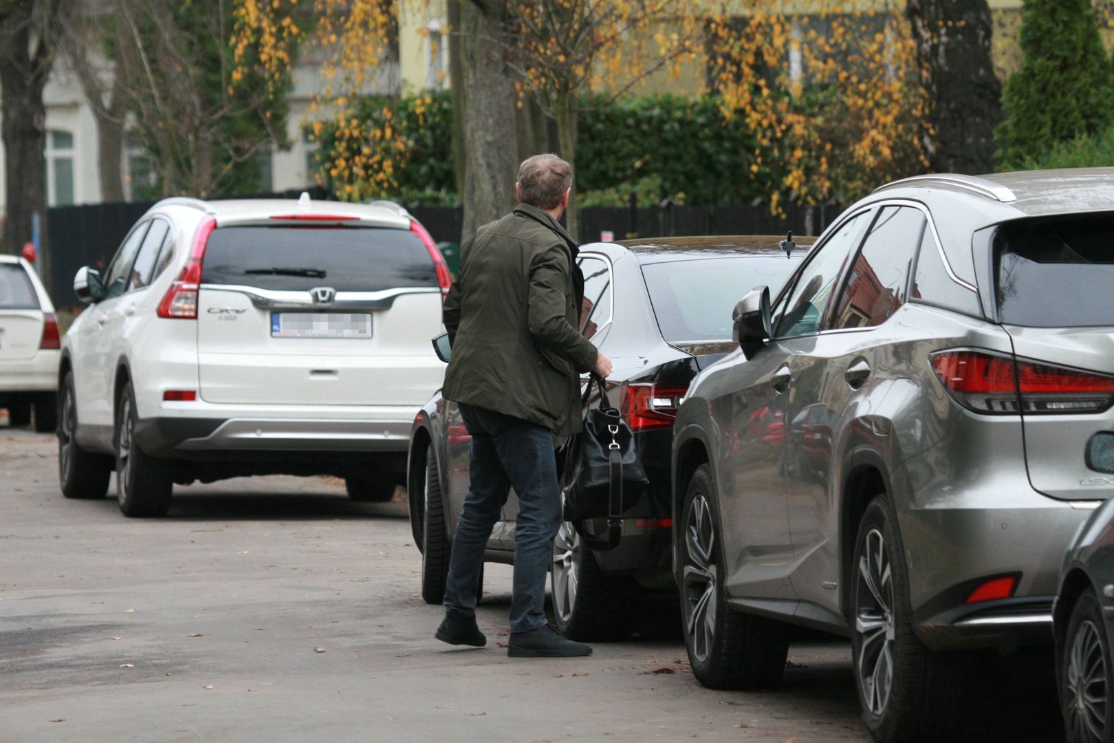 Donald Tusk parkuje auto przed domem. 