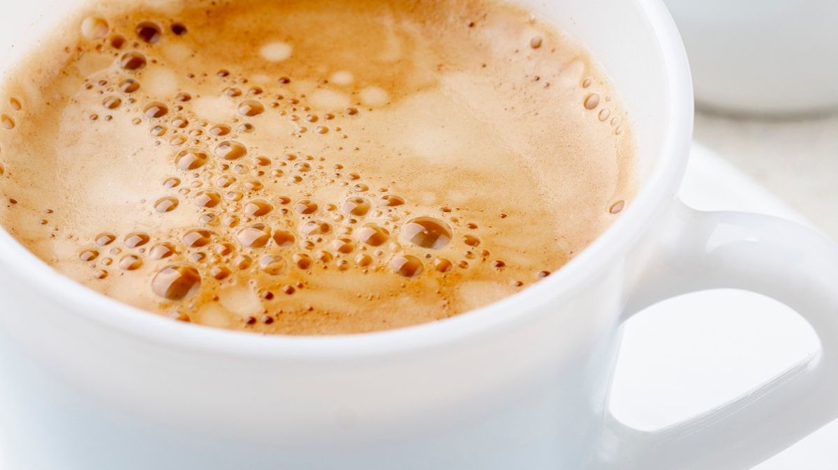 Kawa z pianką w białej filiżance 