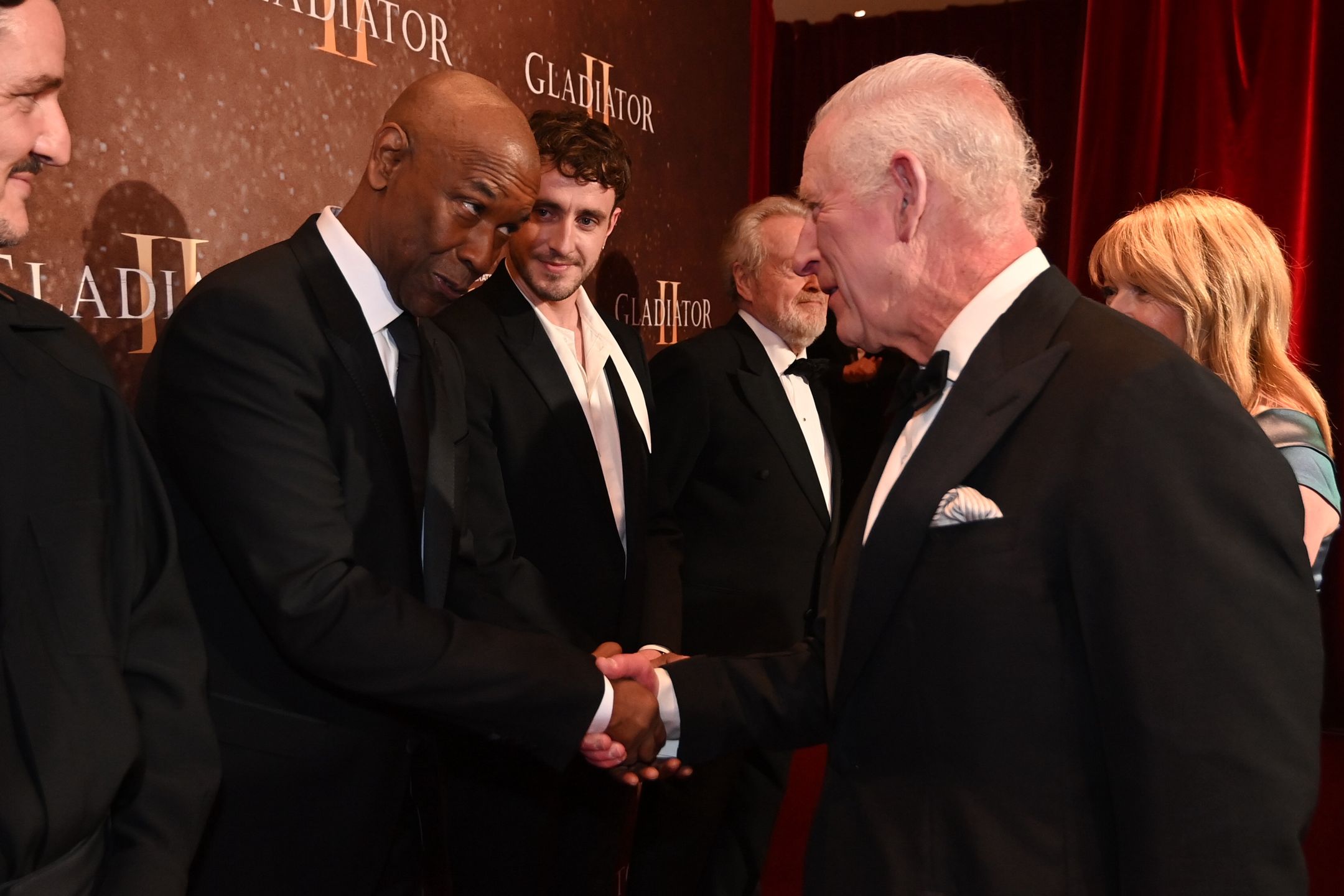 King Charles III Attends The Royal Film Performance Of "Gladiator II"LONDON, ENGLAND - NOVEMBER 13: Pedro Pascal looks on as Denzel Washington meets King Charles III as they attend the Royal Film Performance and Global Premiere of "Gladiator II" in Leicester Square on November 13, 2024 in London, England. (Photo by Eddie Mulholland - WPA Pool/Getty Images)WPA Pool