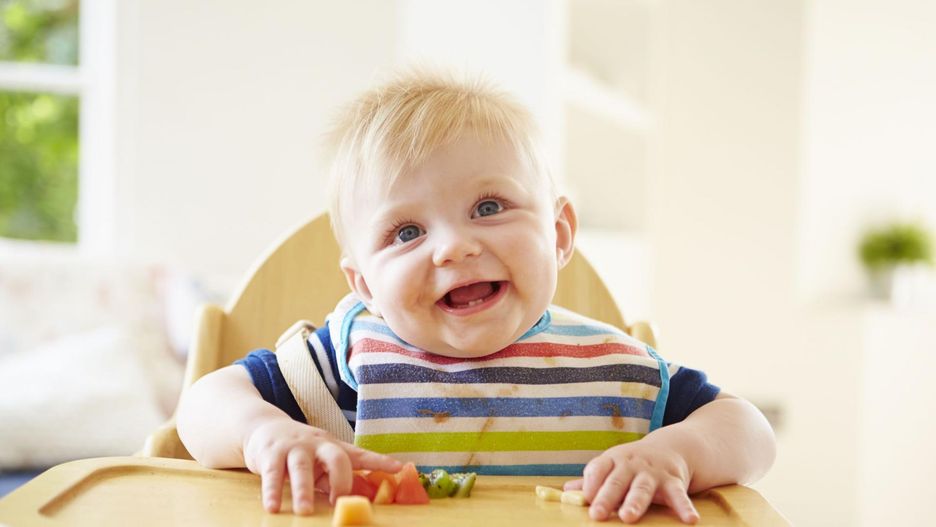 Dziecko w drewnianym krzesełku.