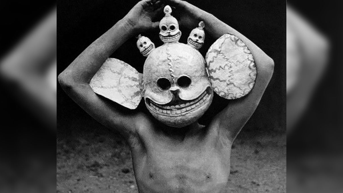 Tybetański szaman z rytualną maską na głowie.