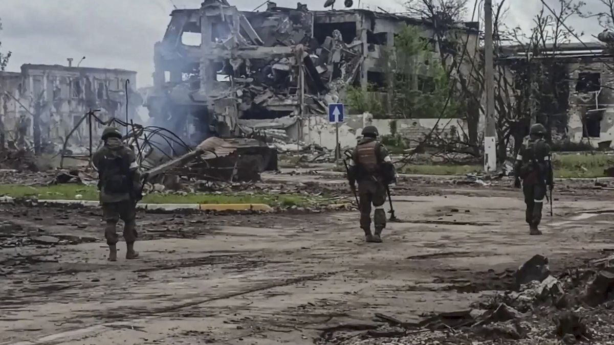 żołnierze w zrujnowanym Mariupolu